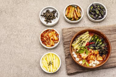 Geleneksel Kore baharatlı çorba, kimchi, tofu, sebze. Sağlıklı yemek için sıcak yemek. Taş beton zemin, üst görünüm
