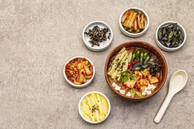Geleneksel Kore baharatlı çorba, kimchi, tofu, sebze. Sağlıklı yemek için sıcak yemek. Taş beton zemin, üst görünüm