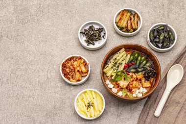 Geleneksel Kore baharatlı çorba, kimchi, tofu, sebze. Sağlıklı yemek için sıcak yemek. Taş beton zemin, üst görünüm
