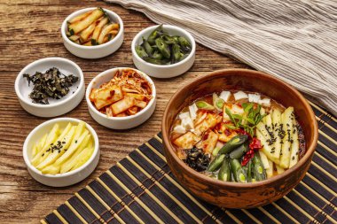 Geleneksel Kore baharatlı çorba, kimchi, tofu, sebze. Sağlıklı yemek için sıcak yemek. Tahta masa arkaplanı, kopyalama alanı