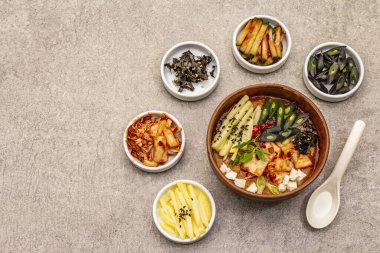 Geleneksel Kore baharatlı çorba, kimchi, tofu, sebze. Sağlıklı yemek için sıcak yemek. Taş beton zemin, üst görünüm
