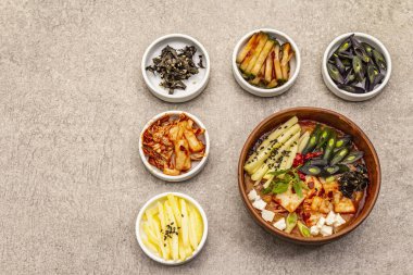Geleneksel Kore baharatlı çorba, kimchi, tofu, sebze. Sağlıklı yemek için sıcak yemek. Taş beton zemin, üst görünüm