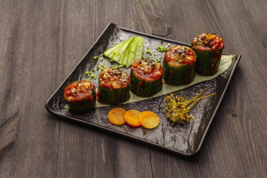 Kore usulü salatalık dolması. Kojori kimchi baharatlı aperatif. Mayalanmış ve marine edilmiş sebzeler. Siyah tahta kaplama arka plan, kapat