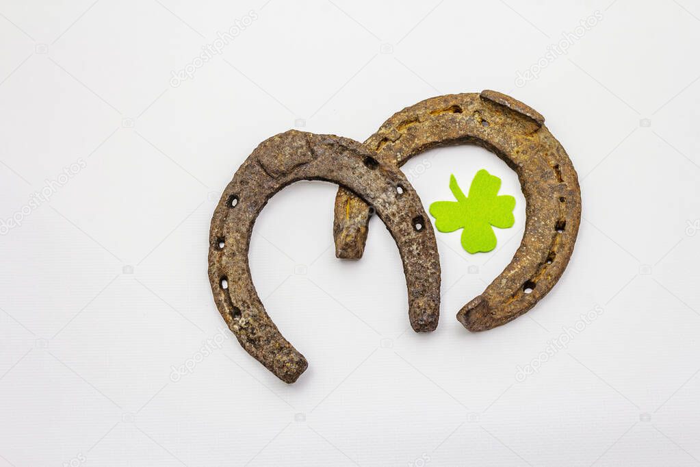 Cast iron metal horse horseshoes isolated on white background. Felt clover leaf, good luck symbol, St.Patrick's Day concept, horse accessories. Template, mockup