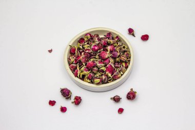 Geleneksel Türk gülü çayı beyaz arka planda izole edilmiş. Seramik kase, kuru çiçekler, taç yaprakları. Sağlıklı yaşam tarzı kavramı