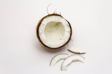 Beyaz arka planda yarım yamalak kesilmiş olgun hindistan cevizi. Taze meyve, yemek pişirmek için malzeme veya güzellik için kişisel bakım.