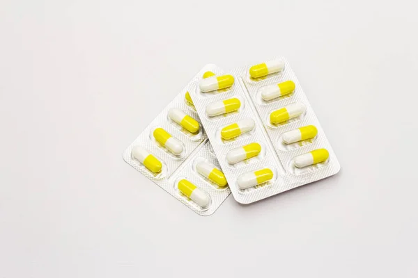 Tabletki Farmaceutyczne Żółte Białe Kapsułki Blistrze Izolowane Białym Tle Leczenie — Zdjęcie stockowe
