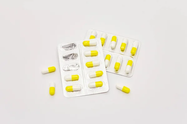 Compresse Farmaceutiche Capsule Bianche Gialle Blister Isolate Fondo Bianco Trattamento — Foto Stock