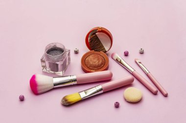 Pembe arka planda makyaj seti. Profesyonel dekoratif kozmetik, güzellik blogcusu konsepti, kapat