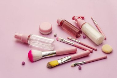 Pembe arka planda makyaj seti. Profesyonel dekoratif kozmetik, güzellik blogcusu konsepti, kapat