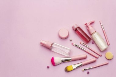 Pembe arka planda makyaj seti. Profesyonel dekoratif kozmetik, güzellik blogcusu konsepti, üst görünüm