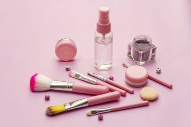 Pembe arka planda makyaj seti. Profesyonel dekoratif kozmetik, güzellik blogcusu konsepti, kapat