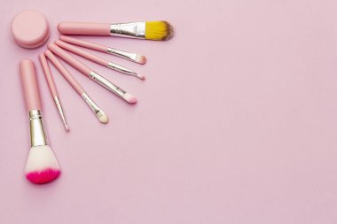 Makyaj fırçaları çeşitliliği. Pembe arka planda kozmetik seti. Profesyonel dekoratif kozmetik, güzellik blogcusu konsepti, üst görünüm