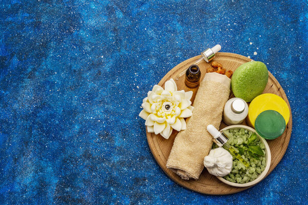 Здоровый ритуал заботы о себе. Натуральная косметика, spa set. Эфирные масла, морская соль, сливки, губка, полотенце. Морской фон, вид сверху
