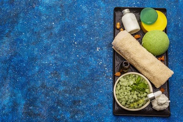 Kendine bakmak için sağlıklı bir ritüel. Doğal kozmetik ürünleri, spa seti. Gerekli yağlar, deniz tuzu, krema, sünger, havlu. Deniz arkaplanı, üst görünüm