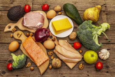Moda ketojenik diyet ürünleri seti. Paleo, pegan düşük karbonhidrat. Et, balık, peynir, meyve ve sebze. Tahta kaplama arka plan