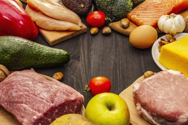Moda ketojenik diyet ürünleri seti. Paleo, pegan düşük karbonhidrat. Et, balık, peynir, meyve ve sebze. Siyah tahta arka plan