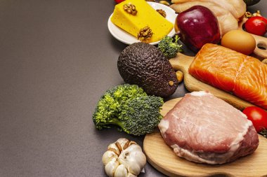 Moda ketojenik diyet ürünleri seti. Paleo, pegan düşük karbonhidrat. Et, balık, peynir, meyve ve sebze. Siyah taş beton arka plan