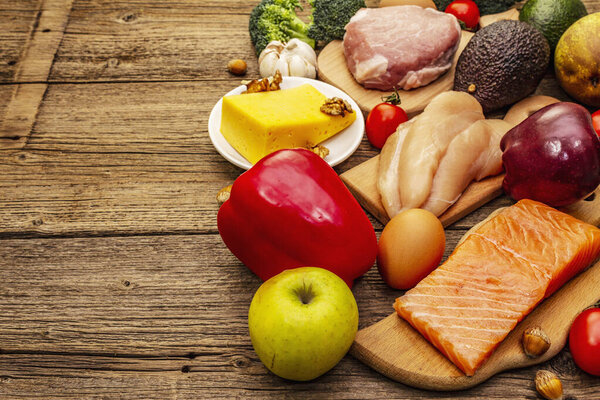 Набор модных кетогенных диетических продуктов. Палео, пиган с низким содержанием углеводов Мясо, рыба, сыр, фрукты и овощи. Деревянные доски
