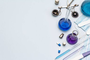 Coronavirüs laboratuvar çalışmaları. Dünya çapında salgın COVID 19, 2019-NCoV, SARS-CoV-2. Tıbbi mataralar, test tüpleri, antikor testi, haplar, toz. Açık mavi arkaplan