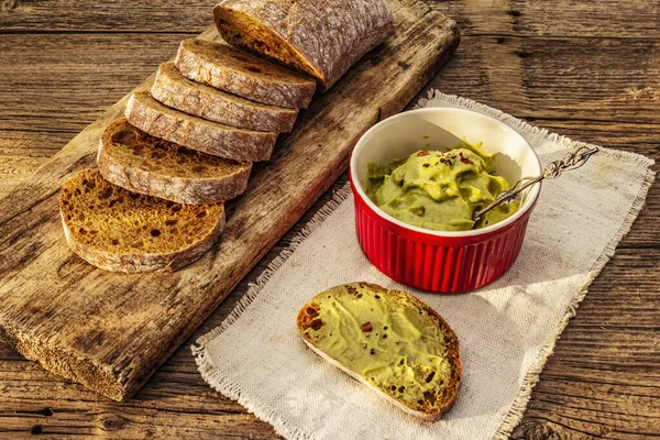 Güneşli sabah kahvaltısı. Sağlıklı yiyecekler, ketojenik diyet konsepti. Taze ekmek, avokado ezmesi, guacamole. Eski tahta tahta arka plan, kopyalama alanı