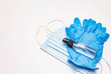 Maske, eldiven, dezenfektan beyaz arka planda. Kişisel hijyen ve viral hastalıkların önlenmesi için tıbbi ürünler. Coronavirus, COVID-19 salgını, 2019-NCoV dünya çapında kavram