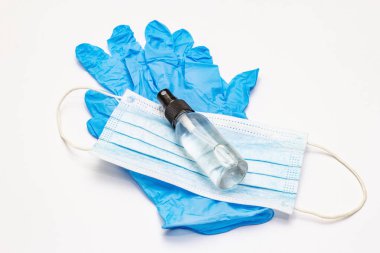 Maske, eldiven, dezenfektan beyaz arka planda. Kişisel hijyen ve viral hastalıkların önlenmesi için tıbbi ürünler. Coronavirus, COVID-19 salgını, 2019-NCoV dünya çapında kavram