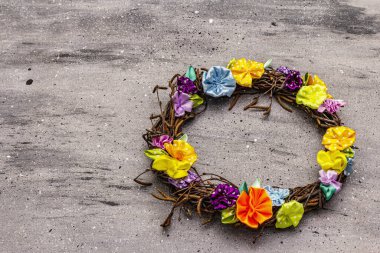 Huş ağacından bir çelengin bahar kompozisyonu ve renkli çiçekler. Saten puantiyeli kurdelelerden yapılan el yapımı, ev konseptinde kalın. Gri taş arkaplan