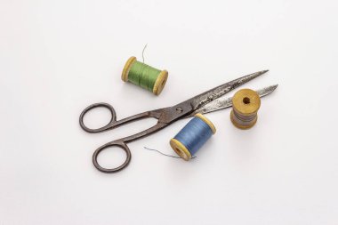 Beyaz arka planda izole edilmiş eski makas ve iplik makaraları. Dikiş, el yapımı, el işi, meslek. İğne işi, DIY konsepti