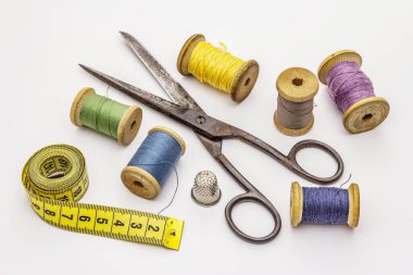 Beyaz arka planda izole edilmiş eski makas ve iplik makaraları. Dikiş, el yapımı, el işi, meslek. İğne işi, DIY konsepti