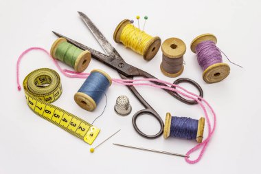 Beyaz arka planda izole edilmiş eski makas ve iplik makaraları. Dikiş, el yapımı, el işi, meslek. İğne işi, DIY konsepti