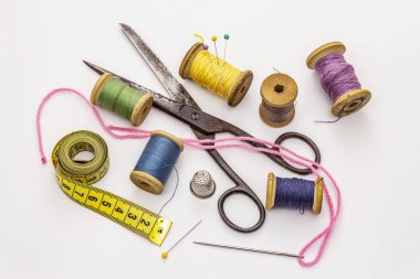 Beyaz arka planda izole edilmiş eski makas ve iplik makaraları. Dikiş, el yapımı, el işi, meslek. İğne işi, DIY konsepti
