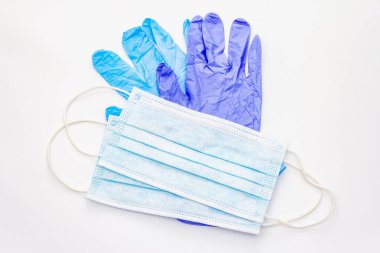 Maske ve eldivenler beyaz arka planda izole edilmiş. Kişisel hijyen ve viral hastalıkların önlenmesi için tıbbi ürünler. Coronavirus, COVID-19 salgını, 2019-NCoV dünya çapında kavram