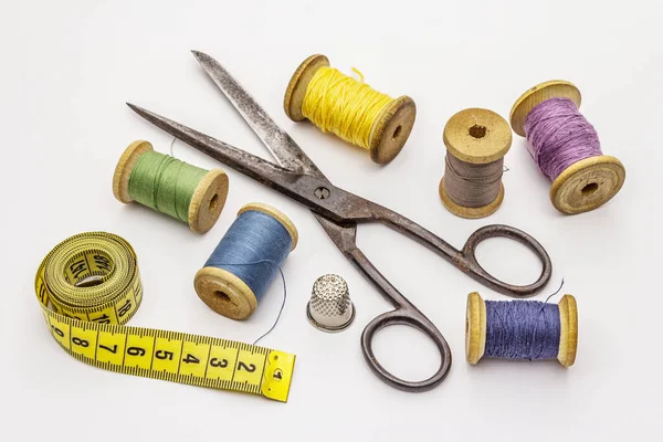Beyaz arka planda izole edilmiş eski makas ve iplik makaraları. Dikiş, el yapımı, el işi, meslek. İğne işi, DIY konsepti
