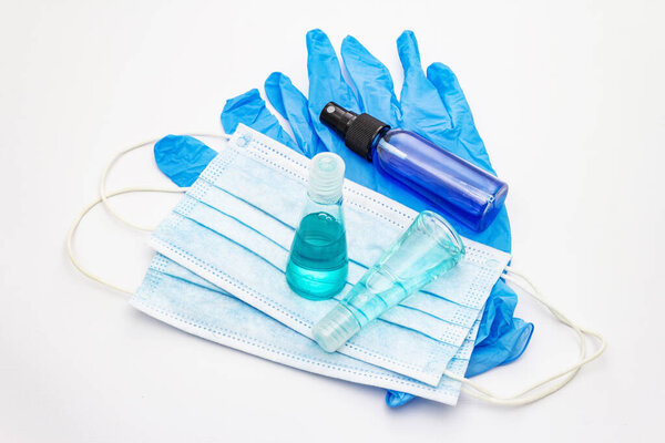 Маска, перчатки, дезинфицирующее средство на белом фоне. Медицинские препараты для личной гигиены и профилактики вирусных заболеваний. Коронавирус, пандемический COVID-19, всемирная концепция 2019-nCoV

