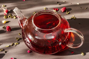 Güneşli sabah kahvaltısı. Kuru meyve, çiçek ve yapraklı çaydanlık içinde ahududu yeşili çay. Moda siyah taş arka planı, kapat