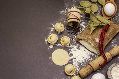 Çiğ hamur köfteleri ve modaya uygun siyah beton arka plan malzemeleriyle kompozisyon. Yemek pişirme süreci, taze ürünler.