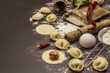 Çiğ hamur köfteleri ve modaya uygun siyah beton arka plan malzemeleriyle kompozisyon. Yemek pişirme süreci, taze ürünler.