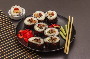 Kore usulü Gimbap (kimbob). Buğulanmış beyaz pirinç (bap) ve diğer malzemeler. Moda siyah taş arka plan