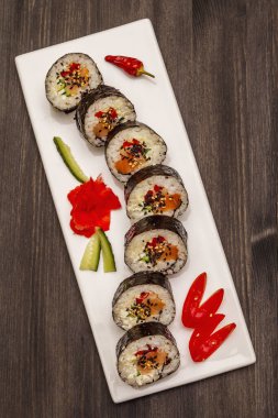 Kore usulü Gimbap (kimbob). Buğulanmış beyaz pirinç (bap) ve diğer malzemeler. Moda siyah tahta kaplama arka planı