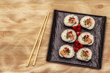 Kore usulü Gimbap (kimbob). Buğulanmış beyaz pirinç (bap) ve diğer malzemeler. Tahta kaplama arka plan