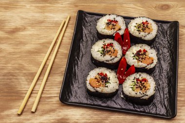 Kore usulü Gimbap (kimbob). Buğulanmış beyaz pirinç (bap) ve diğer malzemeler. Tahta kaplama arka plan