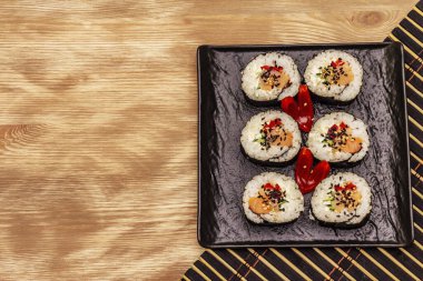 Kore usulü Gimbap (kimbob). Buğulanmış beyaz pirinç (bap) ve diğer malzemeler. Tahta kaplama arka plan