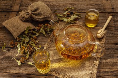 Linden çayı. Kuru kokulu çiçekler. Güneşli sabah kahvaltısı. Bağışıklık sistemini güçlendirmek için sıcak içecek, alternatif tıp. Klasik ahşap masa.