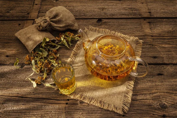 Linden tea. Dry fragrant flowers. Sunny morning breakfast. Hot drink to strengthen the immune system, alternative medicine. Vintage wooden table