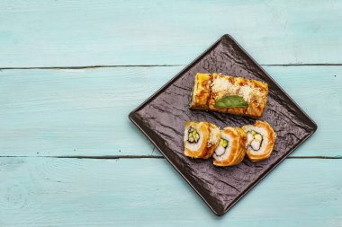 Izgara kaplan karidesli suşi. Farklı taze malzemeli Japon ya da Kore dürümü. Moda turkuaz ahşap tahta arka plan