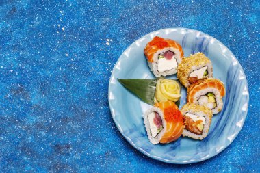 Çeşitli suşi setleri. Farklı taze malzemeli Japon ya da Kore dürümü. Deniz mavisi arkaplan