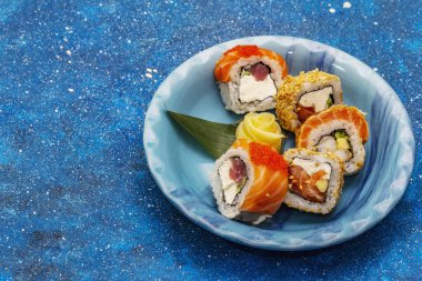 Çeşitli suşi setleri. Farklı taze malzemeli Japon ya da Kore dürümü. Deniz mavisi arkaplan