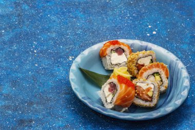 Çeşitli suşi setleri. Farklı taze malzemeli Japon ya da Kore dürümü. Deniz mavisi arkaplan