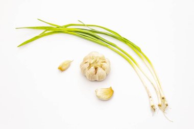 Beyaz arka planda taze sarımsak, baş ve karanfil var. Yemek pişirmek için geleneksel malzeme.